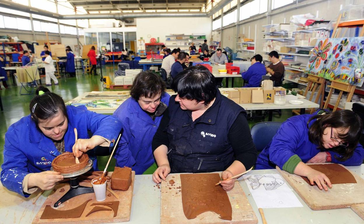 Una monitora imparte un taller en las instalaciones de una asociación para personas con síndrome de Down. 