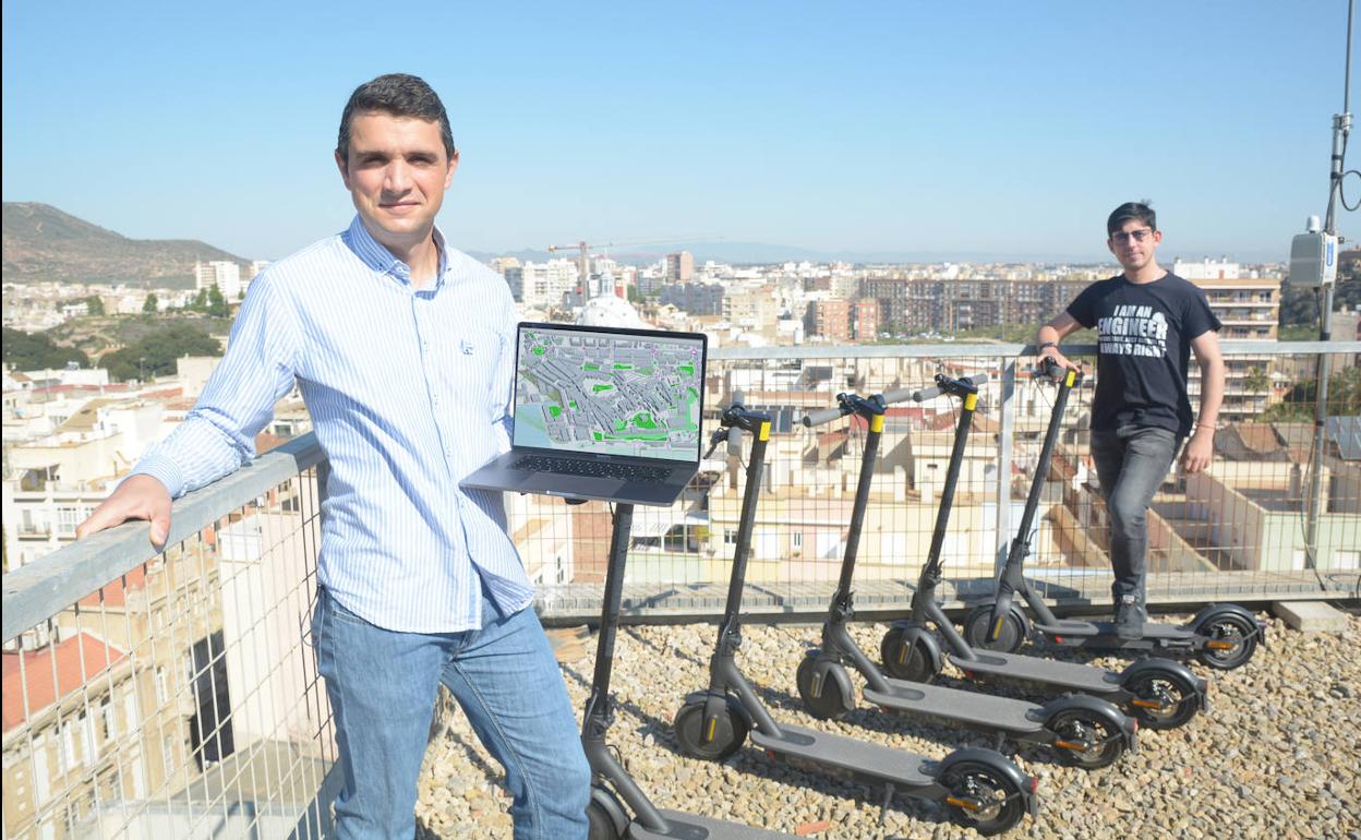 José Santa, con un portátil que muestra recorridos monitorizados, junto a Andrés Ruz y los patinetes y la antena instalada en el ELDI.