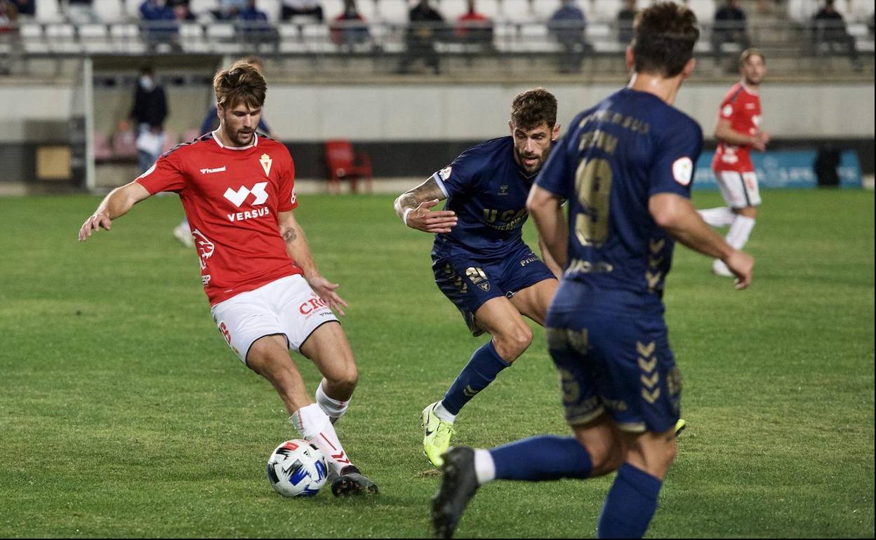 Mario Abenza conduce el balón, en el último Real Murcia-UCAM en el Enrique Roca, con Adri León a su lado.
