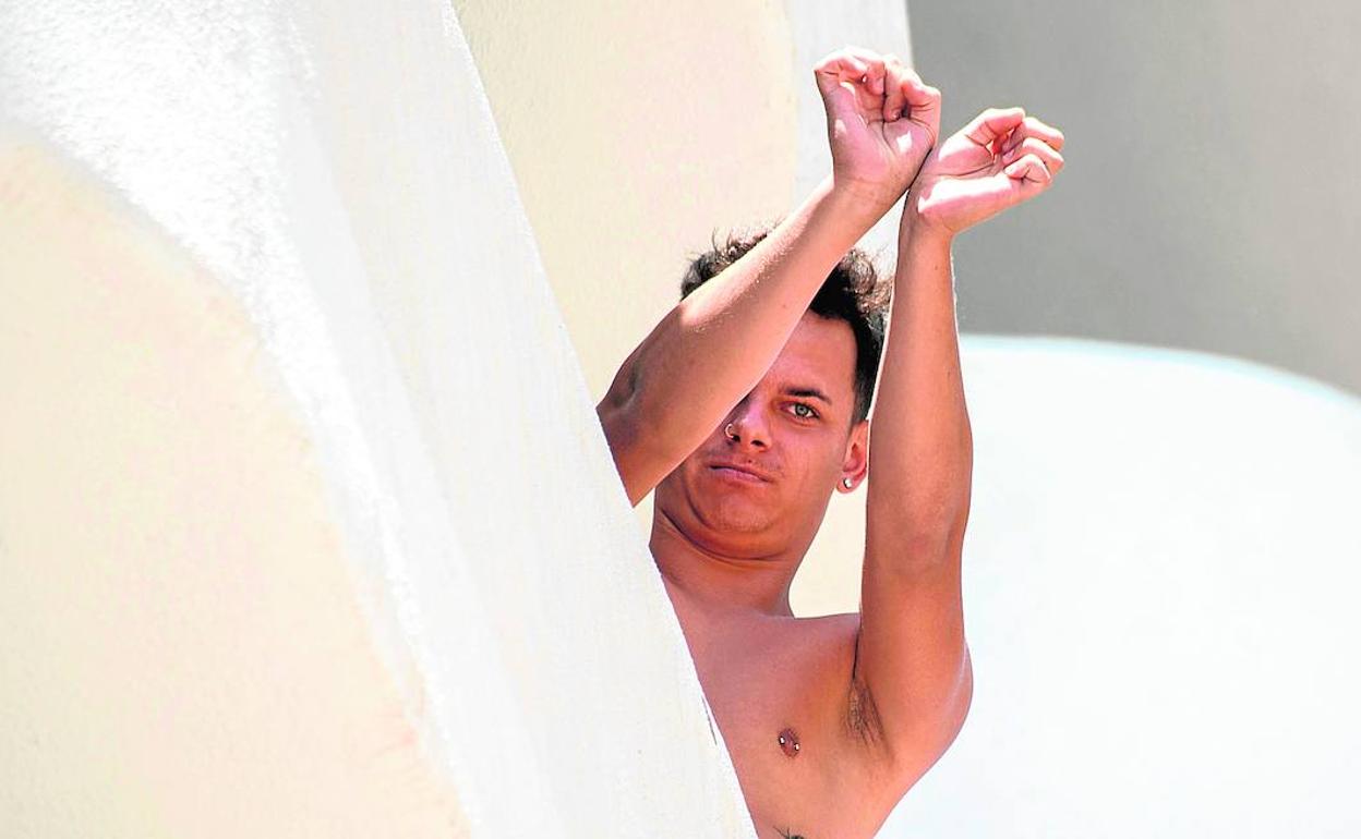 Un joven confinado en el hotel Bellver de Palma de Mallorca hacía este lunes el gesto de estar retenido contra su voluntad.