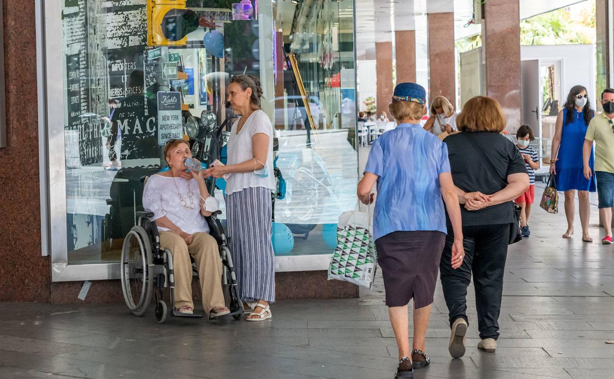 Mujeres hidratándose y resguarándose a la sombra durante la ola de calor en Murcia. 