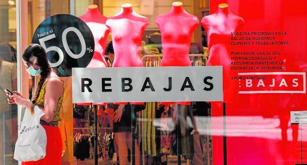 Una joven pasa por delante de un escaparate del centro de Murcia, en una imagen de archivo.