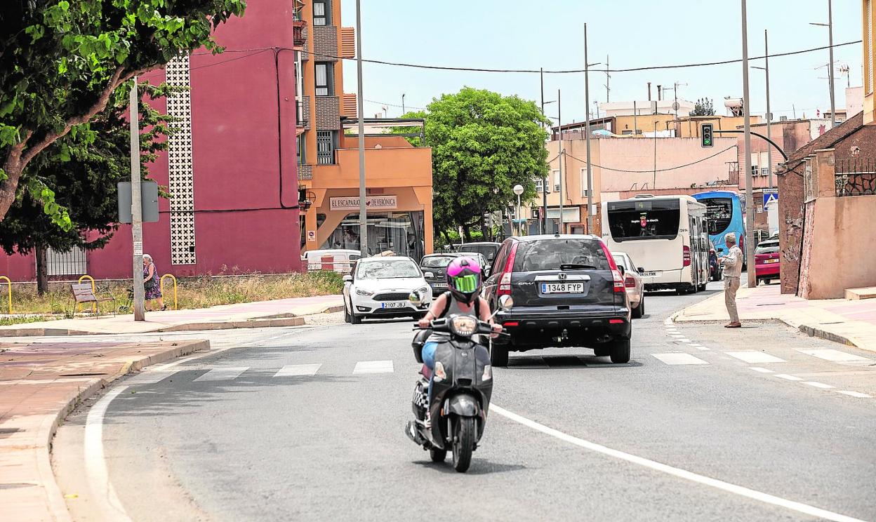 Vehículos por la calle Peroniño, que la obra contratada pretende librar de inundaciones. 