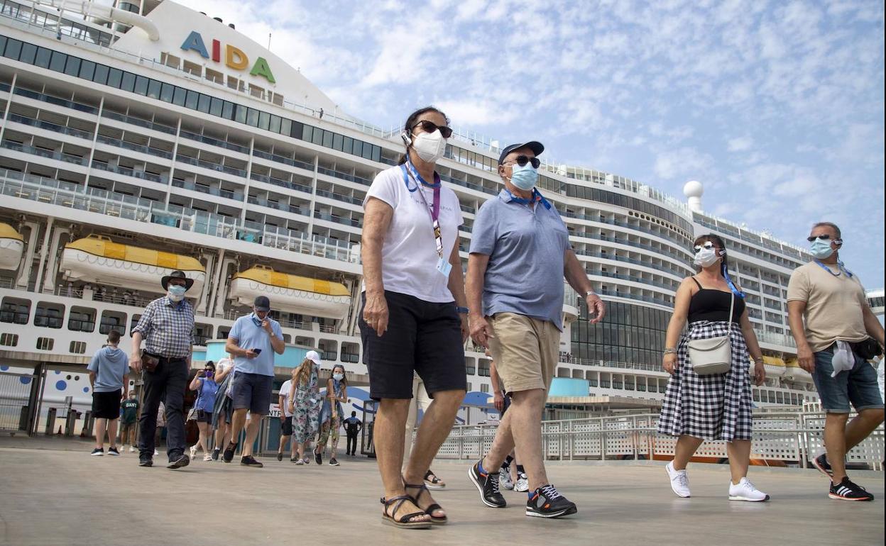 Turistas descienden del barco para una excursión a pie por la ciudad.