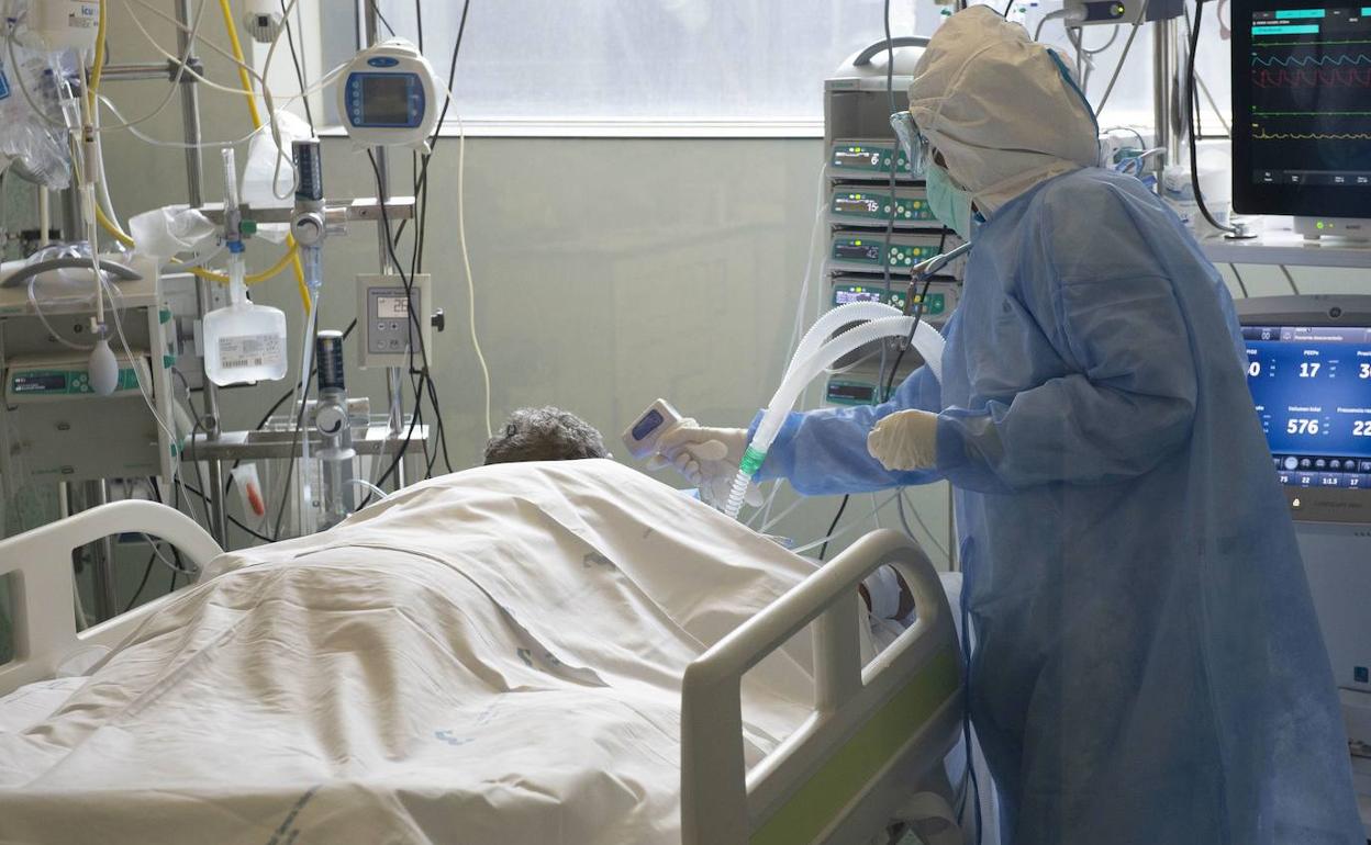 Una sanitaria atiende a un enfermo en una UCI del hospital Santa Lucía de Cartagena.