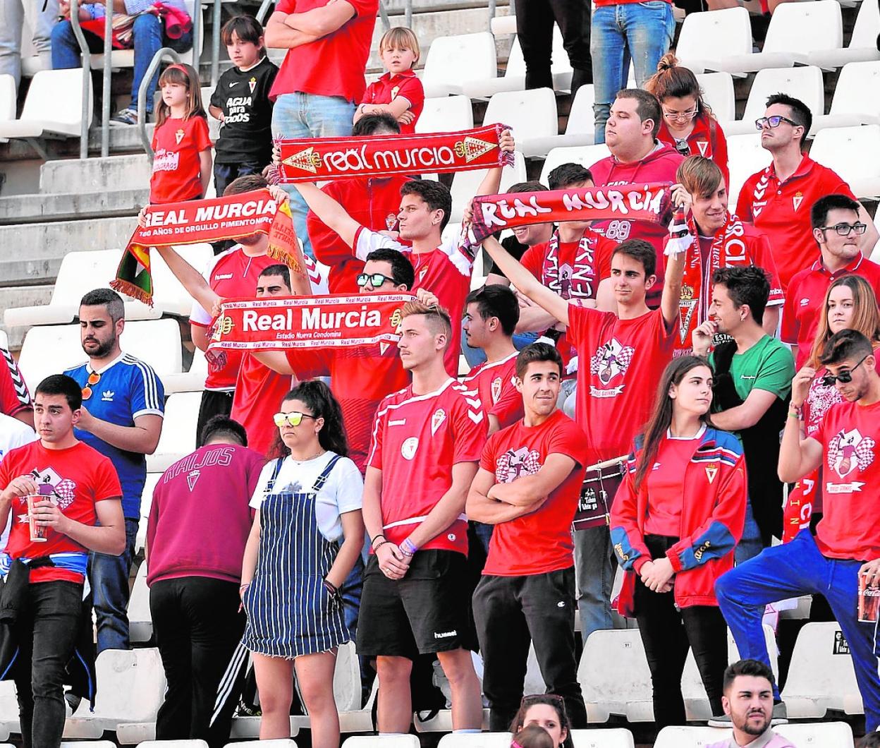 Seguidores del Real Murcia mostrando sus bufandas desde un fondo del estadio Enrique Roca. 