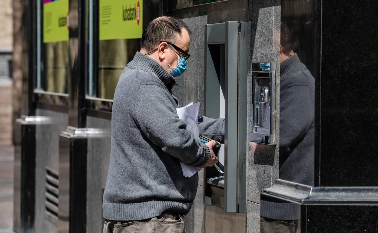 Un hombre sacando dinero del cajero.