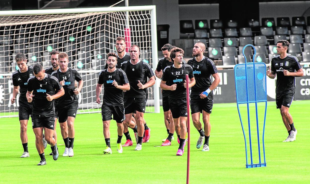 La plantilla albinegra estira las piernas, antes de empezar el entrenamiento de esta semana en el estadio Cartagonova. 