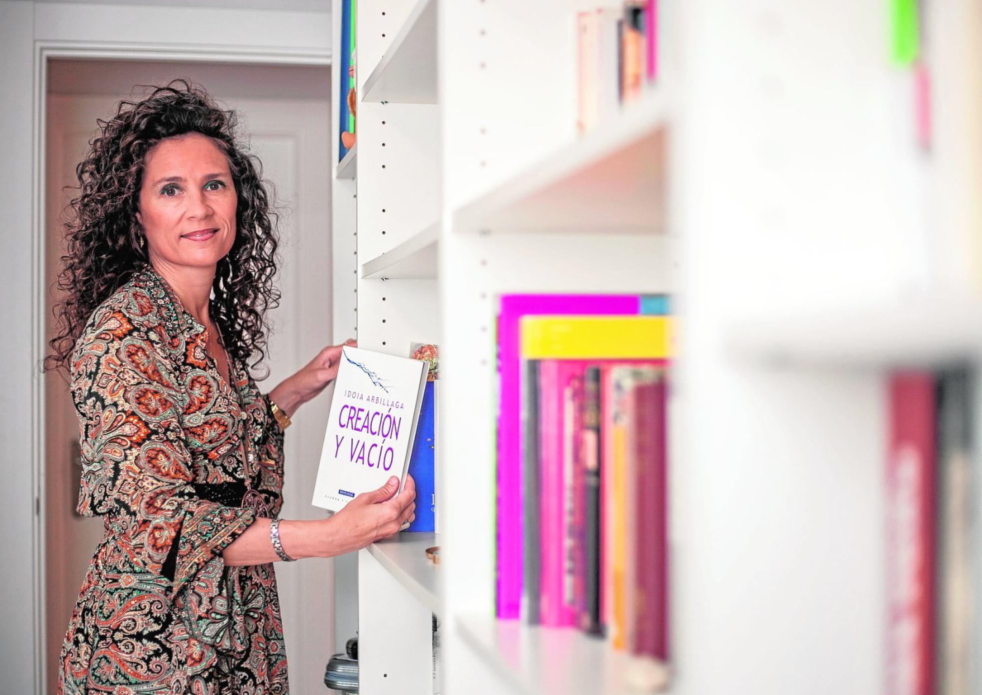 Idoia Arbillaga, en su biblioteca personal, con un ejemplar de 'Creación y vacío'. 
