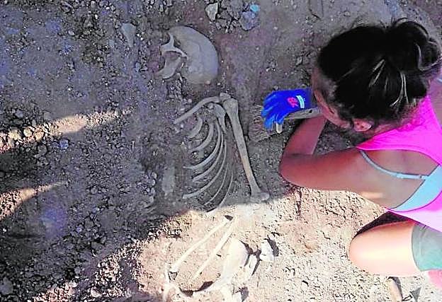 Una experta examina un esqueleto humano en la isla del Fraile. 