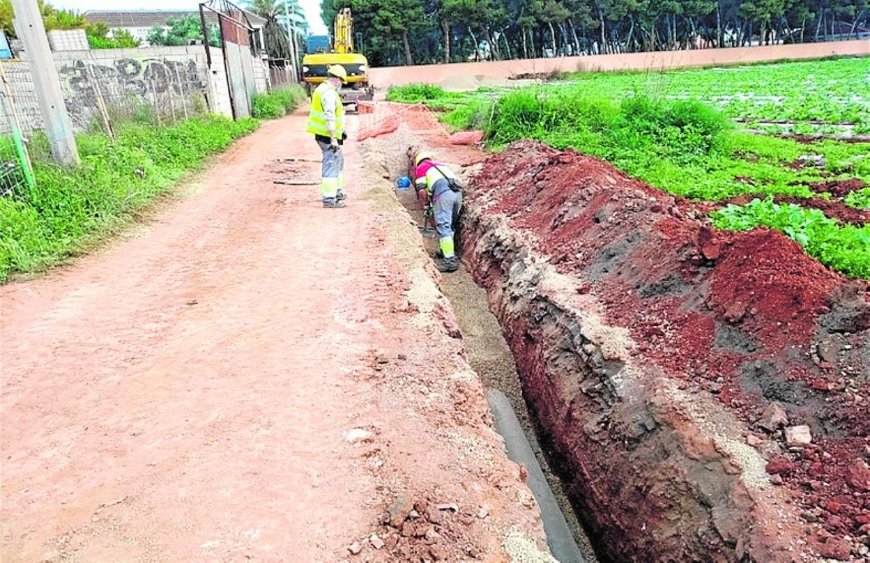 Dos operarios, revisando una canalización en Los Urrutias. 