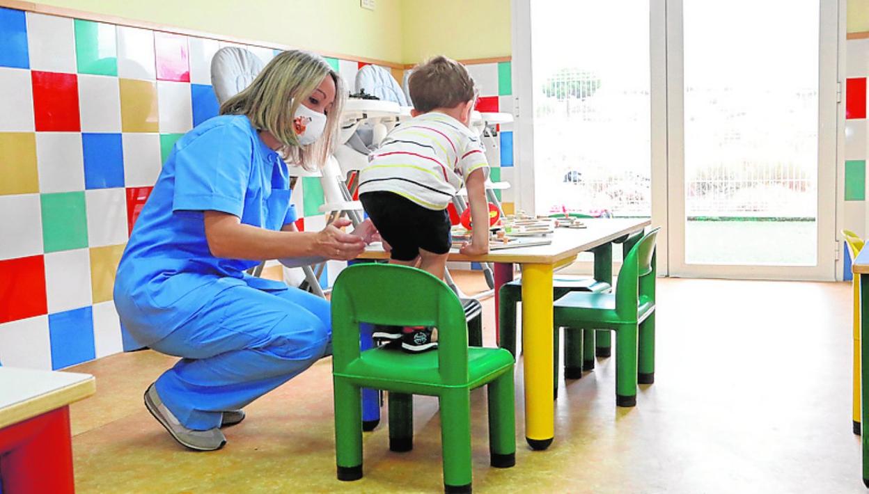 Una educadora atiende a un niño en la guardería de La Hoya, ayer. 