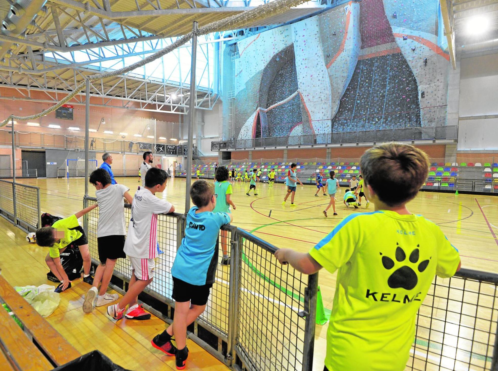Jugadores de las bases del CD Murcia de fútbol sala entrenando en el Cagigal, con el rocódromo cerrado de fondo.