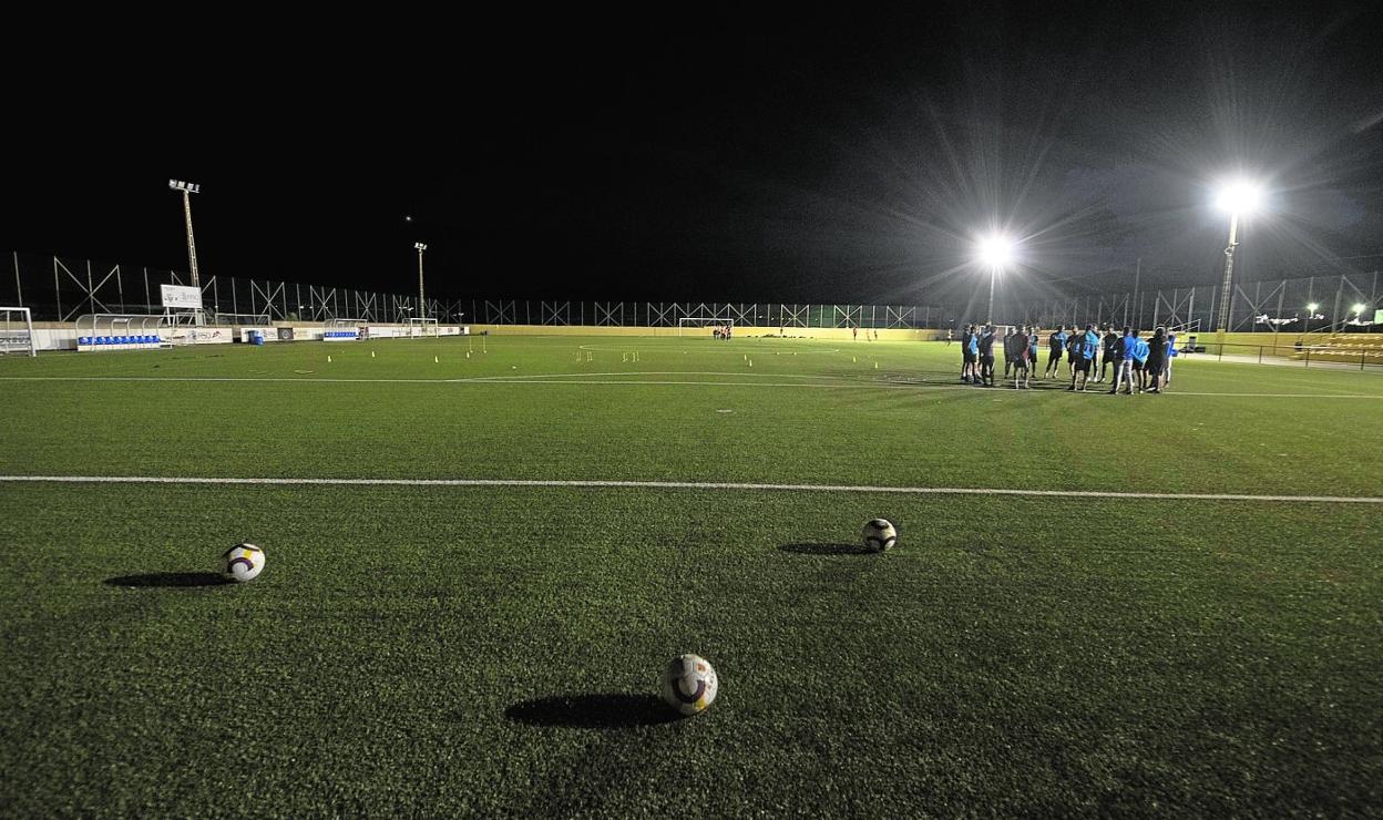 Los jugadores de La Aljorra, al fondo, antes de empezar el entrenamiento de anoche en el Luis Guarch, con las torres de la izquierda apagadas. 