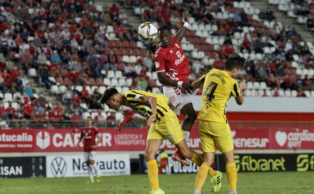 Jugadores se disputan un balón.