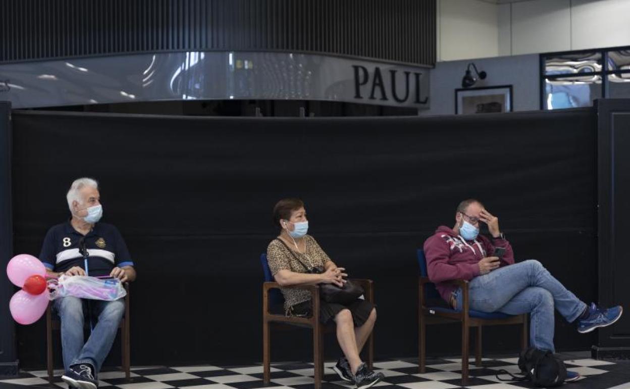 Varias personas aguardan en el interior del aeropuerto de Barajas. 