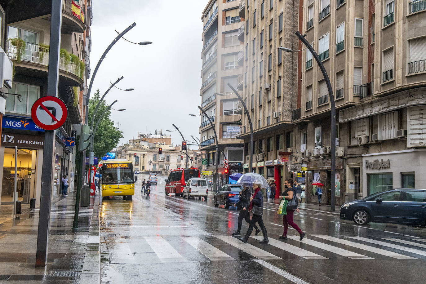 Varias personas se protegen de la lluvia en la Gran Vía de Murcia, en una imagen de archivo.