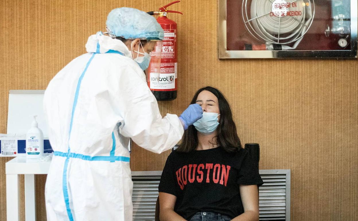 Un sanitario realiza una prueba PCR a una paciente, en una fotografía de archivo.