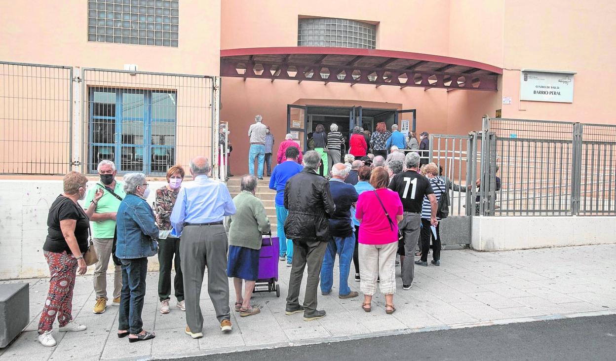 Vecinos de Cartagena hacen cola para entrar al centro de salud de Barrio Peral para la vacuna de la gripe y la tercera dosis. 