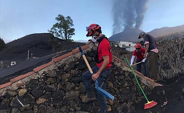 Los voluntarios de Cruz Roja dedicaron parte de su labor a retirar residuos del volcán de los tejados de las viviendas para evitar que se hundieran. 