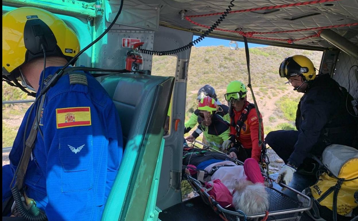 Efectivos de emergencias, con la mujer rescatada. 