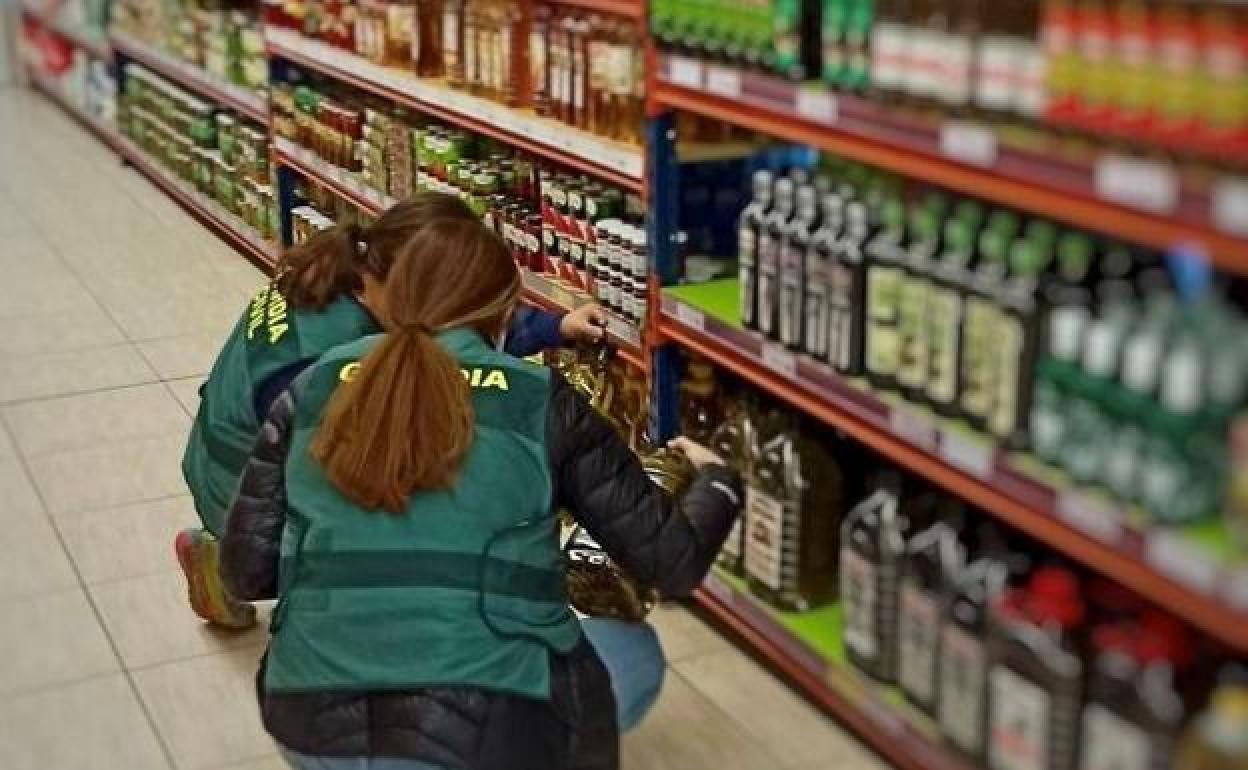 Agentes de la Guardia Civil investigan algunos de los alimentos distribuidos por la banda desarticulada.