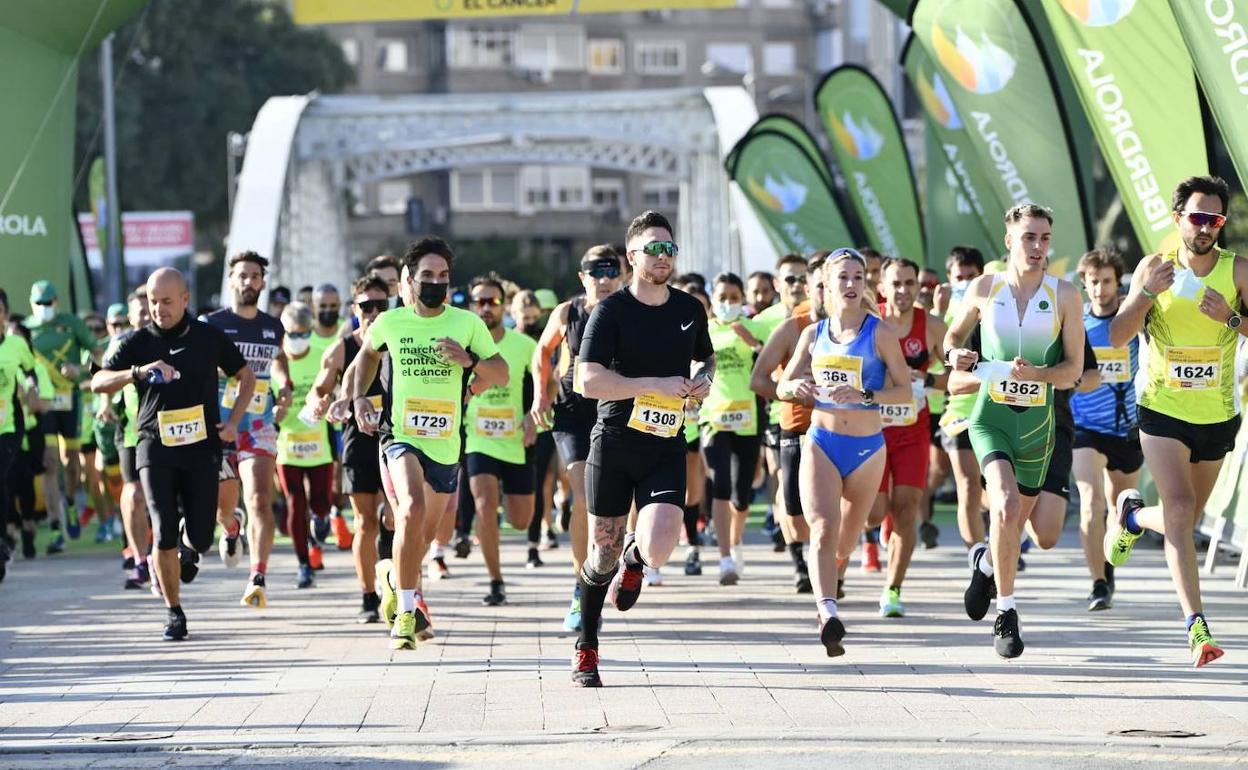 Salida de la carrera popular, este domingo, en el Puente Nuevo de Murcia.