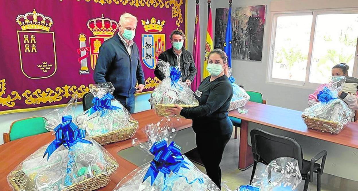 Una madre recoge unas de las cestas de manos del alcalde, ayer. 