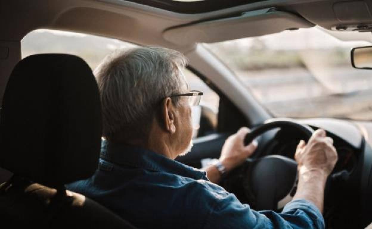 Un hombre conduciendo un coche.
