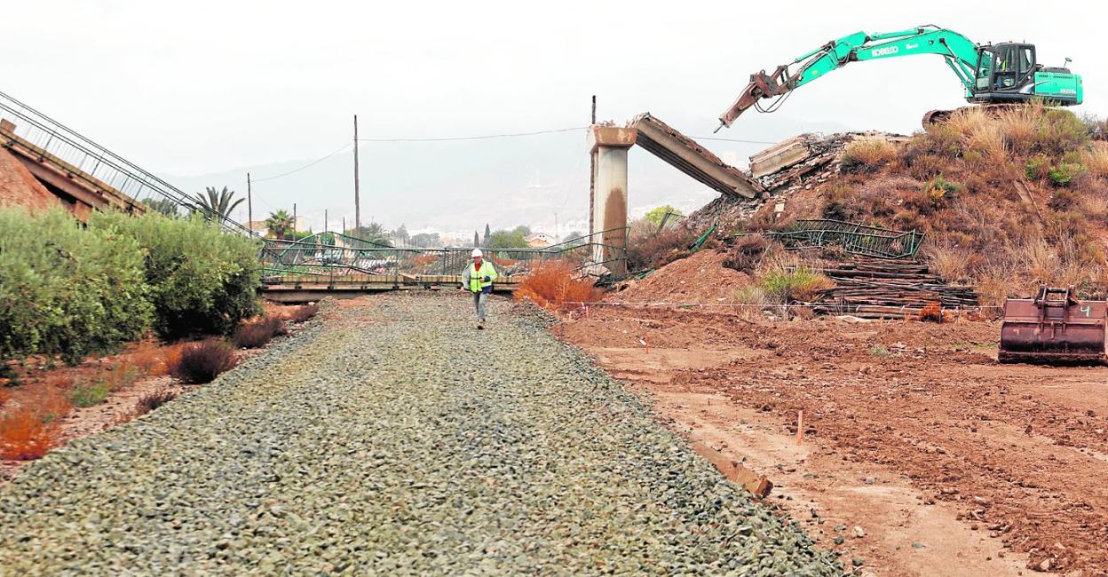 Maquinaria pesada derriba, ayer, el puente del Camino de Enmedio sobre la vieja plataforma del tren donde se levantará el viaducto. 