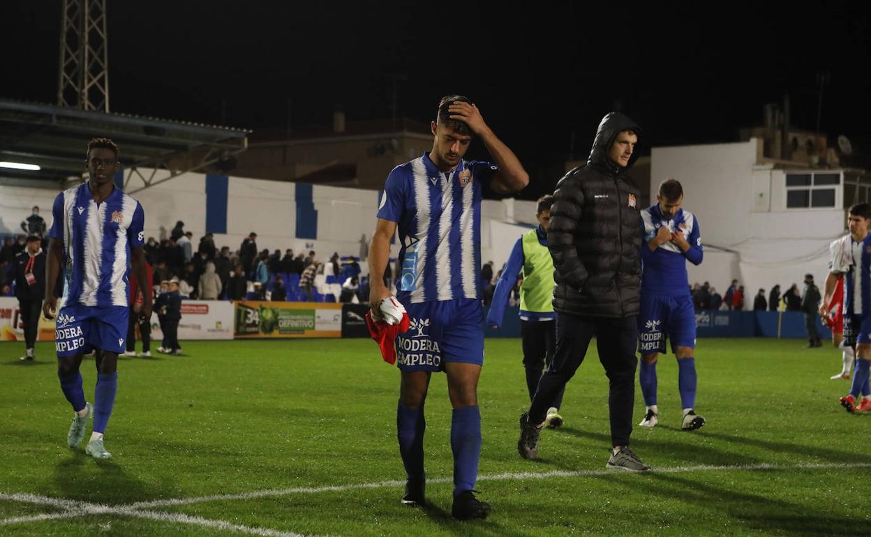Los jugadores del Águilas se retiran tristes tras rozar la proeza ante el Almería, anoche.