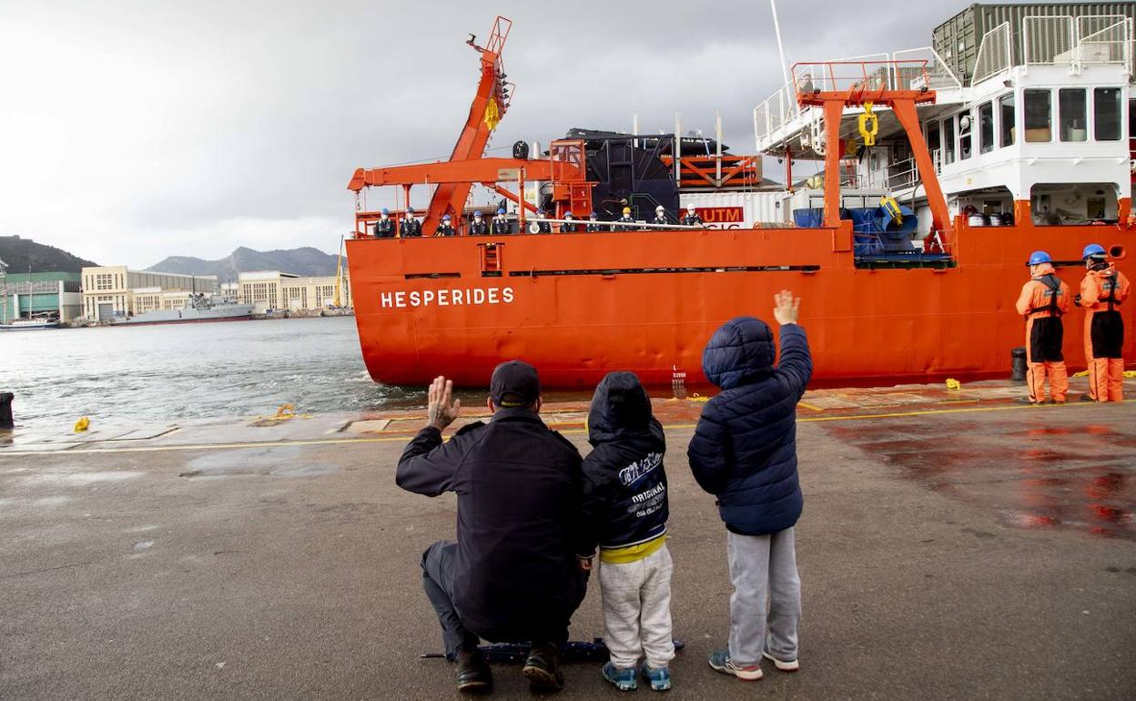 Un hombre y dos niños despiden a los marinos del 'Hespérides', durante la maniobra de salida en el Arsenal Militar de Cartagena. 