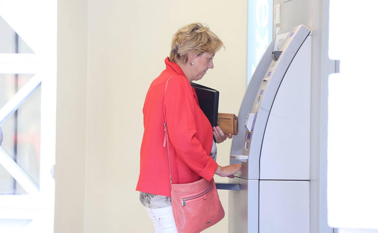 Una mujer utiliza un cajero automático.