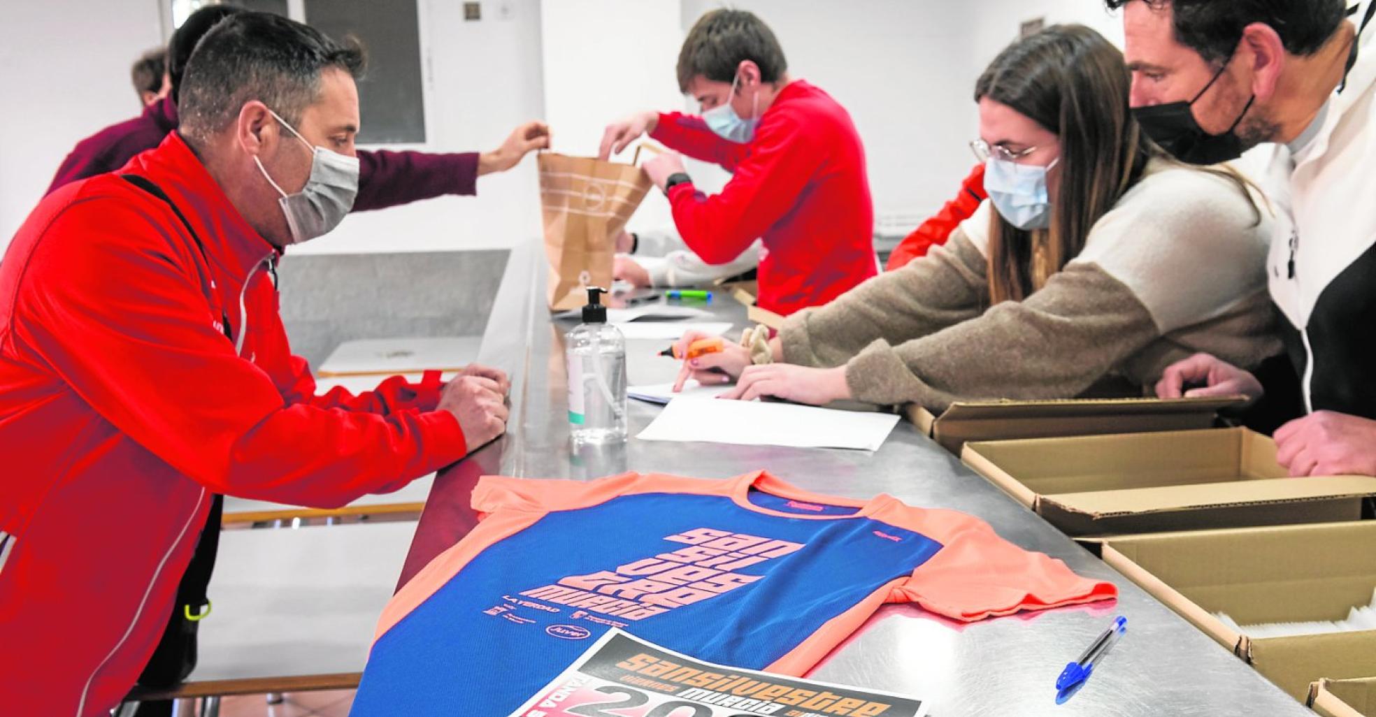 Varios corredores retirando su dorsal y su camiseta, ayer en el Príncipe de Asturias.