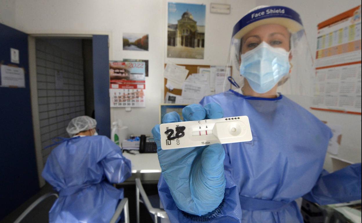 Una sanitaria del centro de salud del Carmen de Murcia muestra un test positivo de coronavirus, este martes.