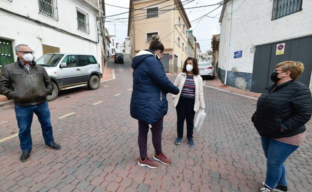 Vecinos de Benizar conversan entre ellos en la plaza. 