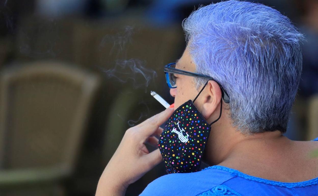 Una mujer fumando en una terraza, en una imagen de archivo. 