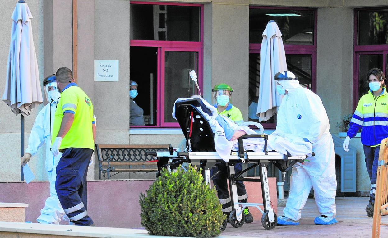 Trabajadores sanitarios y sociosanitarios trasladan a la ambulancia a un usuario de la residencia San Basilio, en noviembre de 2020. 