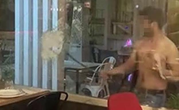 El hombre destroza el cristal del restaurante. 