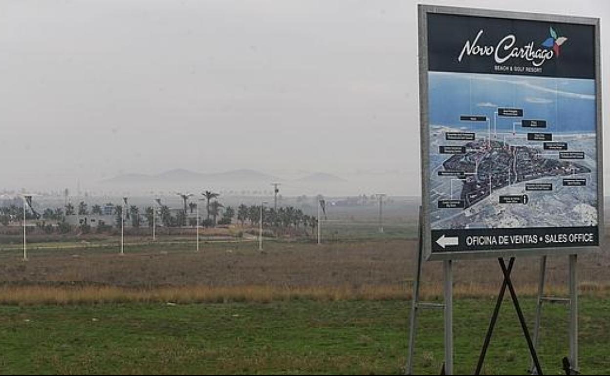 Vista de los terrenos de Novo Carthago, tras un cartel de la promoción y ante el Mar Menor. 
