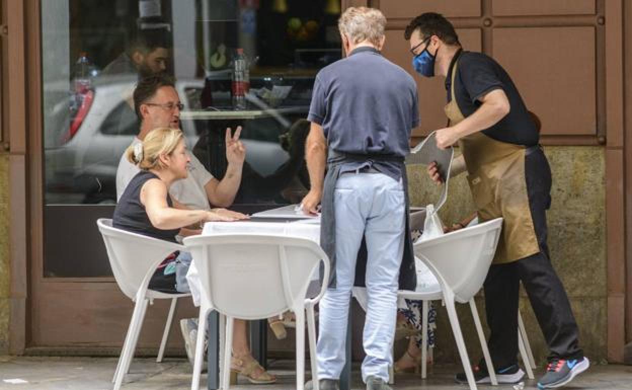 Dos camareros atendiendo en una terraza, en una imagen de archivo.