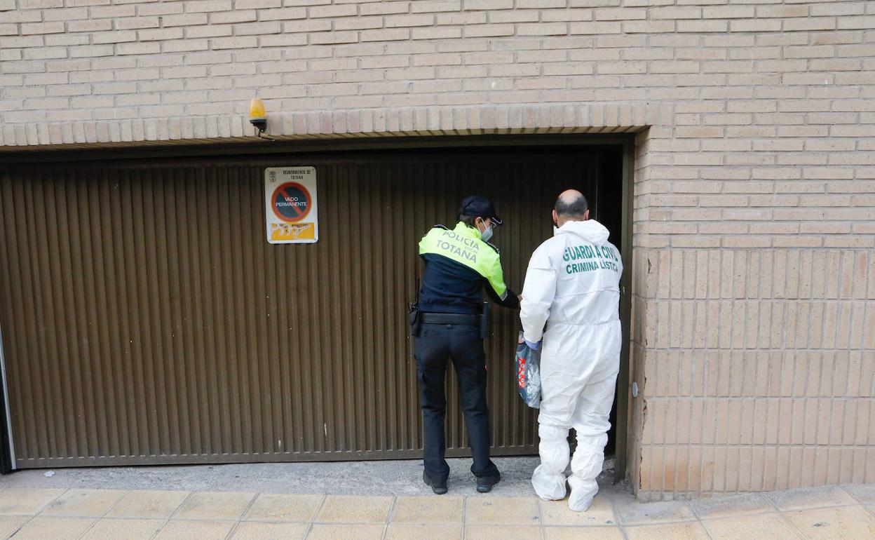 Agentes de Policía y Guardia Civil, durante la inspección de la vivienda donde fue hallado el cuerpo.