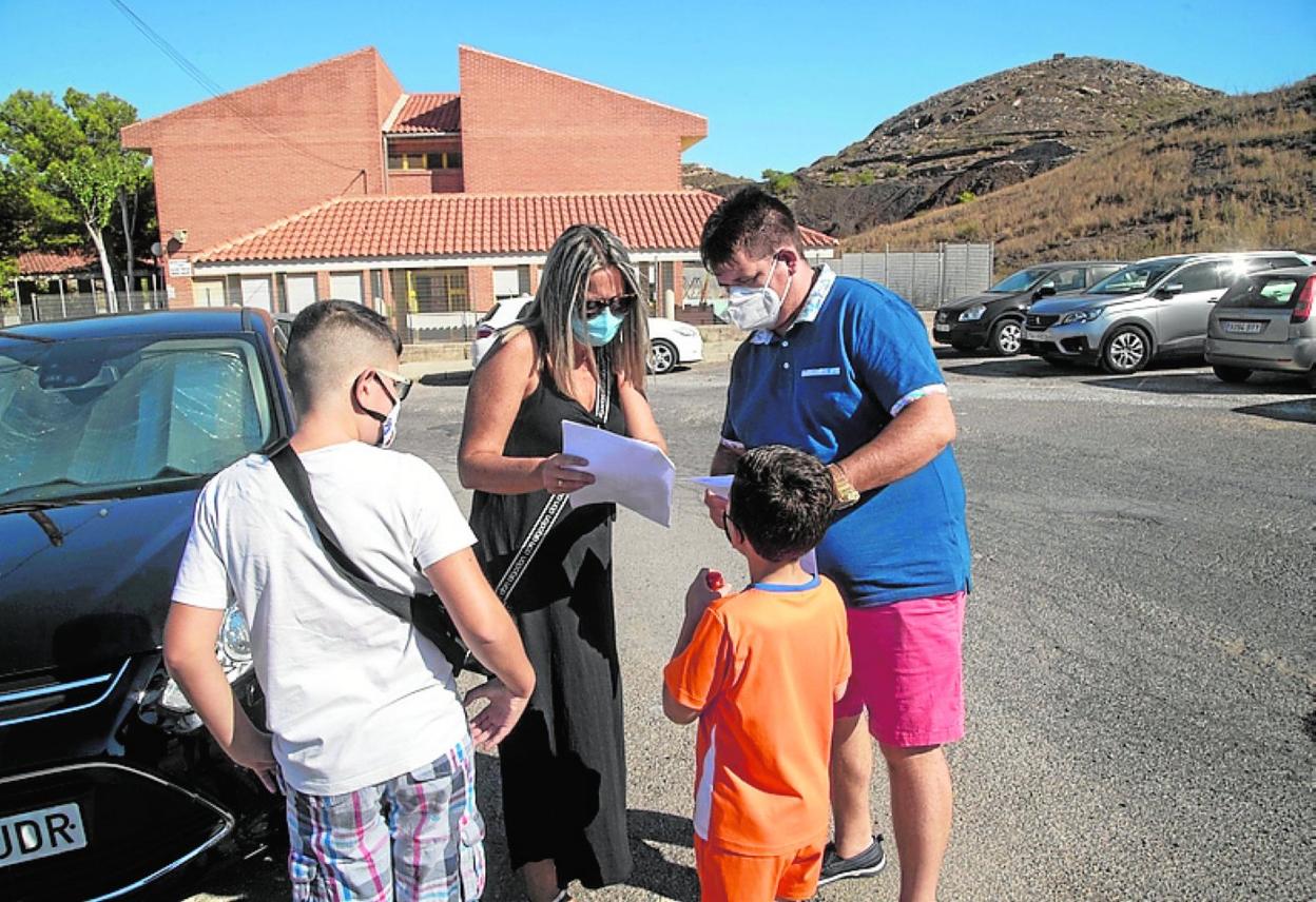 Dos padres, con sus hijos, frente al colegio Enrique Viviente en 2020. 