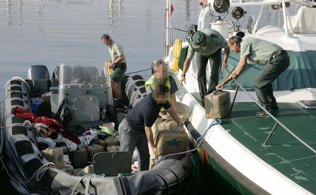 Guardias civiles descargando un alijo de hachís de una planeadora. 