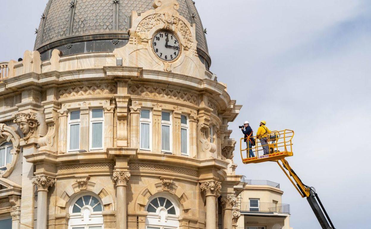 Dos operarios en una grúa revisan la cúpula del Ayuntamiento. 