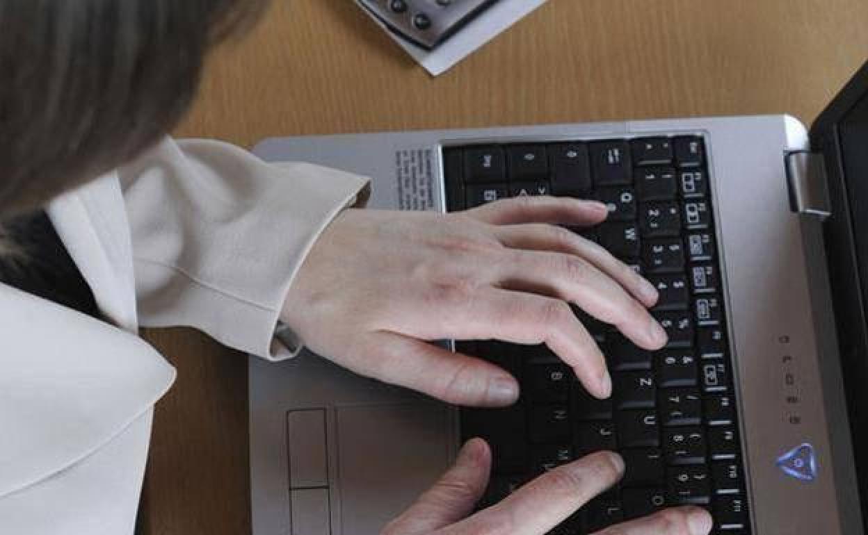 Una mujer trabaja en un ordenador. 