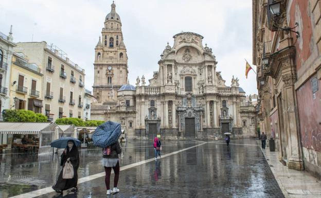 Varias personas se protegen de la lluvia con un paraguas en Murcia, en una imagen de archivo.