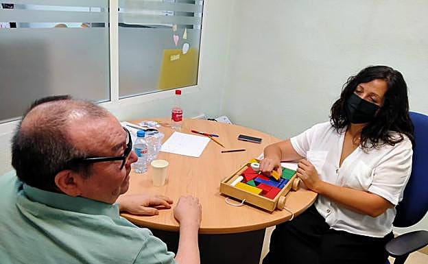 Un usuario realiza actividades de motricidad con una de las profesionales de ADFA. 