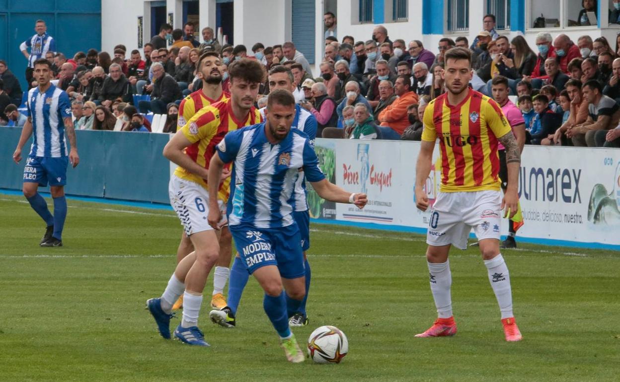 El aguileño Víctor Fenoll controla el balón, acosado por un rival. 