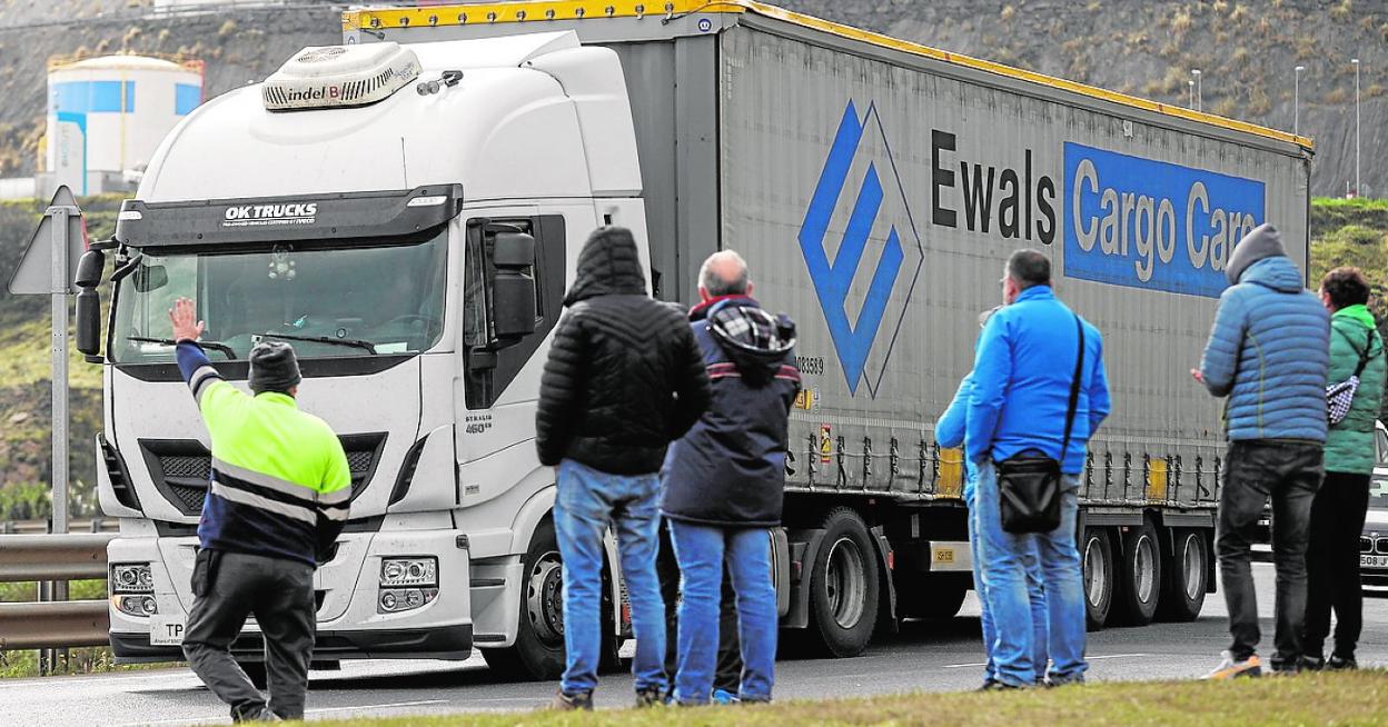 Un pequeño grupo de piquetes vigila el paso de un camión de transportes, ayer. 